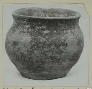 Pottery vessel from Marion with a rounded body and short flaring rim, shown on a mounted card