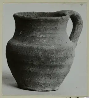 Plain pottery jug with a single handle, identified as Pottery Plain White VII from tombs 1–30