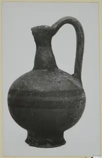Jug with a single loop handle and a rounded body, photographed against a pale background