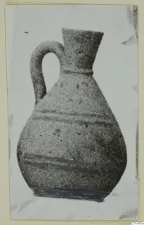 Pottery White Painted VI jug with a loop handle and flaring neck, shown with dark painted bands