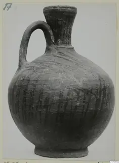 Pottery jug with a single handle, a flared neck and dark vertical strokes on its body