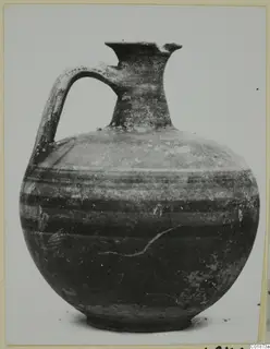 Bichrome-Red jug with one handle and dark horizontal bands, shown against a pale background