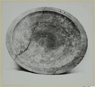 Pottery bowl from Marion seen from above, cracked across its body, with two small holes near the rim.