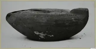 Terracotta lamp from Marion, tombs 31–45, shown from the side on a pale surface