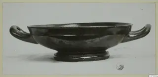 Black glazed pottery bowl with two horizontal handles and a ring foot, from Marion tombs 31–45.