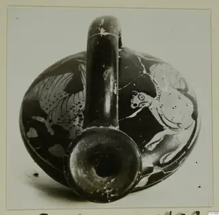 Round-bodied pottery vessel with a tall loop handle and painted figures on its body, neck opening facing the camera