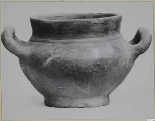 Two-handled pottery vessel with a wide mouth and a short foot, shown against a plain background.