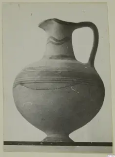 White Painted I jug with a single loop handle, a wavy band on the neck and horizontal bands on the body.