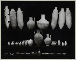 Pottery vessels from Vouni, Tomb 14, arranged in three rows on a dark background