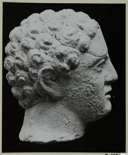 Head of a sculpture in pale stone from Mersinaki, shown in profile facing right, with rows of curled hair