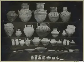 White Painted III-1 pottery: jars, jugs and bowls arranged in rows on dark cloth