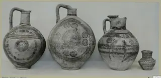 Four painted pottery vessels from Marion, Tomb 13, standing in a row against a pale backdrop.