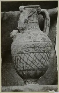Painted pottery vessel with a strap handle and a modelled head at the neck, Pottery Black-on-Red III_V - V_VII