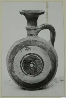 Bichrome pottery juglet with a flared neck, loop handle and concentric circles on its body