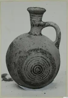 Pottery White Painted II juglet with a loop handle and dark concentric circles painted on its body