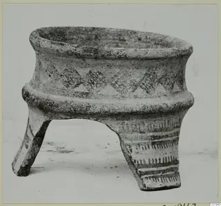 Pottery White Painted I vessel on three legs, with painted triangle motifs and bands, photographed against a plain background.