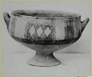 White Painted I bowl with two side handles and a footed base, decorated with lozenges and vertical bands
