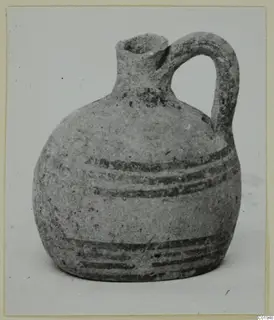White Painted II jug from Lapithos with a single loop handle and dark painted bands on the body
