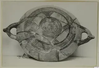 Pottery Bichrome II, a shallow two-handled vessel with dark concentric circles and triangular motifs painted on its surface