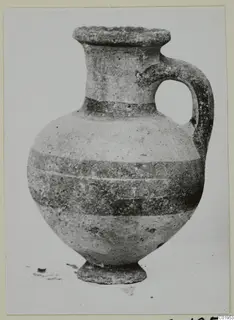 Pottery Bichrome II jug from Lapithos, with a single loop handle and dark horizontal bands on its body