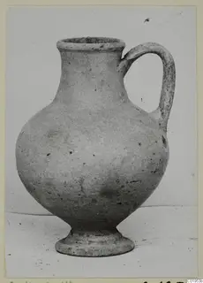 Pottery Plain White I-III jug with a flared rim, rounded body, ring foot and single loop handle