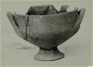 Pottery White Painted I bowl from Lapithos, with a footed base, two handles and a broken rim with sherds at the back.