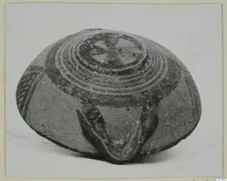 White Painted I bowl, photographed at an angle, with concentric rings and a central motif on its upper surface