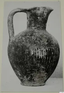Black slip jug with a strap handle and vertically ribbed lower body, from Lapithos