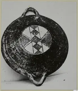 Black slip painted pottery vessel with two loop handles and a hatched geometric pattern in its central panel