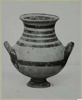 White Painted I amphora with dark horizontal bands, two side handles and a low ring foot, seen from the side.