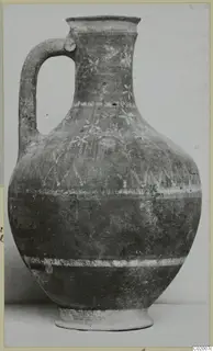 Painted pottery jug with a strap handle, light bands and flower-like motifs on the body