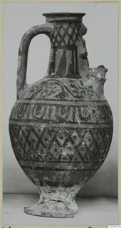 Pottery White Painted VI jug with a single loop handle, broken spout and dark painted bands and lattice on pale clay
