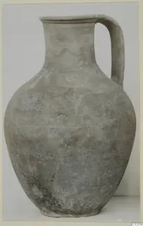 Pottery jug, White Painted VII, with a single strap handle and a faded wavy painted band on the neck