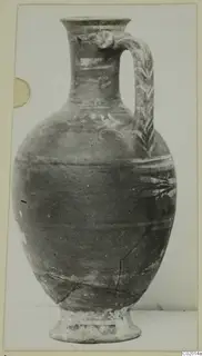 Bichrome-Red pottery jug with a strap handle and painted bands, photographed against a plain background