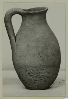 Pottery Plain White VI juglet with a single loop handle and a flaring rim