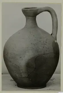 Pottery Plain White VI jug with a single handle and a cracked body