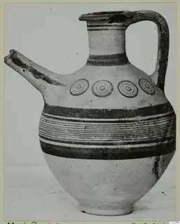 White Painted IV juglet with a long spout, strap handle, concentric circles and horizontal painted bands