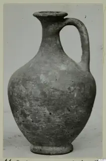 Cypro-Hell.I. pottery jug with a single loop handle, photographed against a pale background