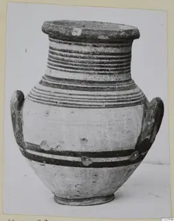Pottery White Painted IV amphora with two loop handles and horizontal dark painted bands on a pale surface.