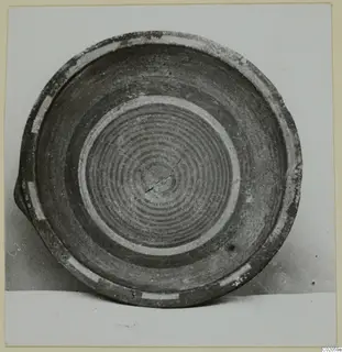 Plate of Bichrome-Red pottery seen from above, with concentric dark rings in its interior and pale bands near the rim.