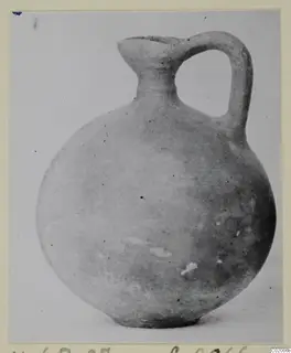 Round-bodied jug with a single loop handle and a flared mouth, a find from Marion photographed on a plain background