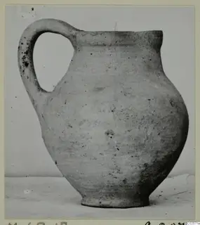 Pottery jug with a single loop handle and a wide globular body, photographed against a plain background.