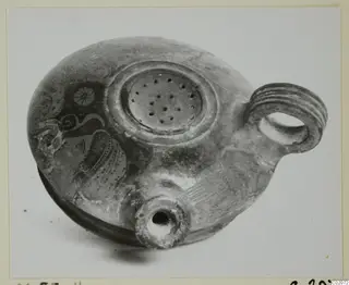Pottery lamp with a perforated filling disc, ribbed loop handle and short nozzle, with painted decoration