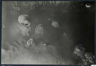 Tomb 72 at Marion during excavation, with pottery vessels lying on the sandy floor of the chamber.