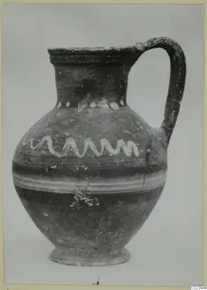 Jug with a strap handle, painted with a white wavy band and a row of white dots on the body