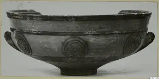 Pottery Black-on-Red bowl with two side handles and concentric circle motifs on the body, seen from the side