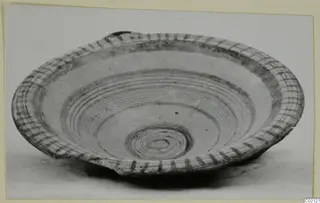 Shallow painted plate or bowl from Marion, with concentric dark bands and a cross-hatched rim
