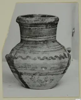 Small pottery amphoriskos with two handles and painted bands, with a wavy dark motif on the shoulder