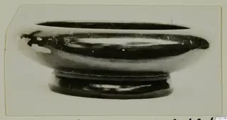 Pottery Black Glazed Ware bowl with a short ring foot, seen from the side.