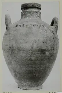 Two-handled pottery amphora with a wide rim and a row of dark marks on the shoulder.